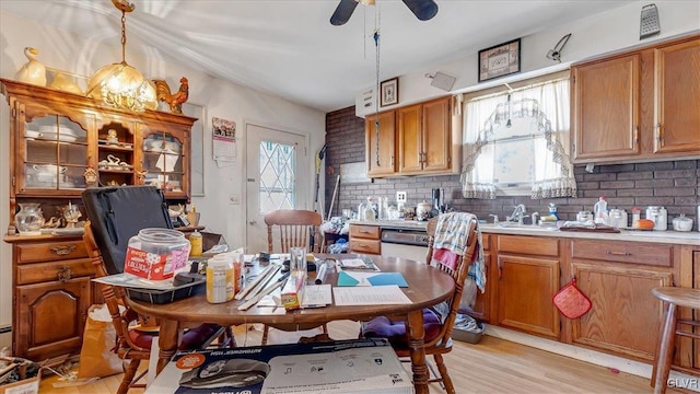 kitchen with a wealth of natural light, brown cabinets, tasteful backsplash, and light countertops