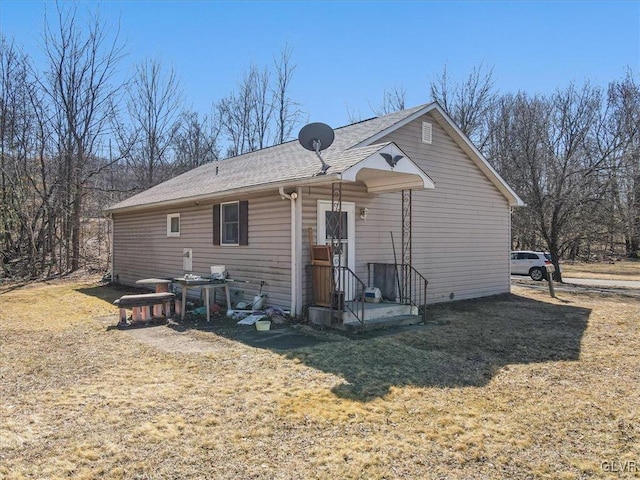 rear view of house featuring a yard