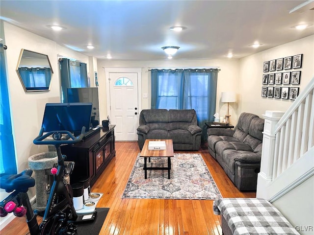 living area featuring stairs and light wood finished floors