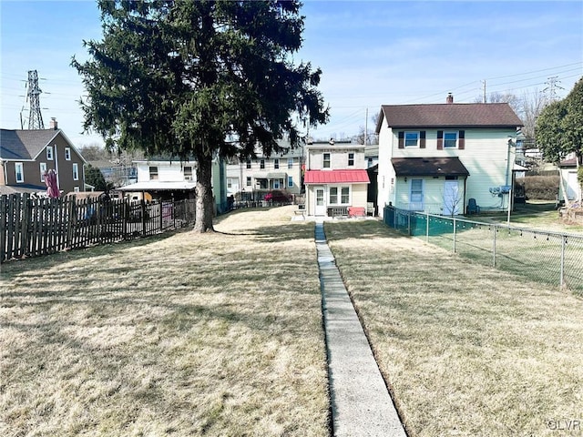 back of property with a chimney, a lawn, and fence private yard