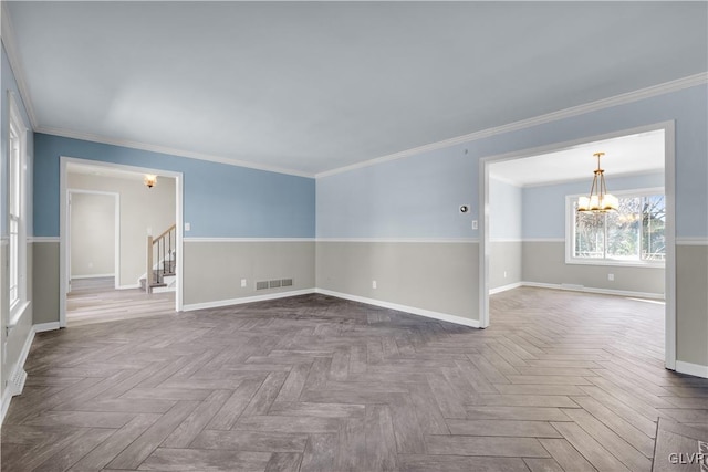 unfurnished room with visible vents, crown molding, baseboards, stairway, and a notable chandelier