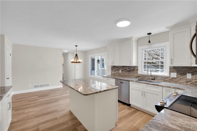 kitchen with a healthy amount of sunlight, a sink, decorative backsplash, dishwasher, and light wood-type flooring