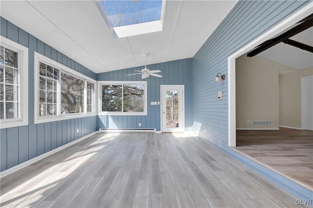 unfurnished sunroom featuring visible vents, lofted ceiling with skylight, a ceiling fan, and a baseboard radiator