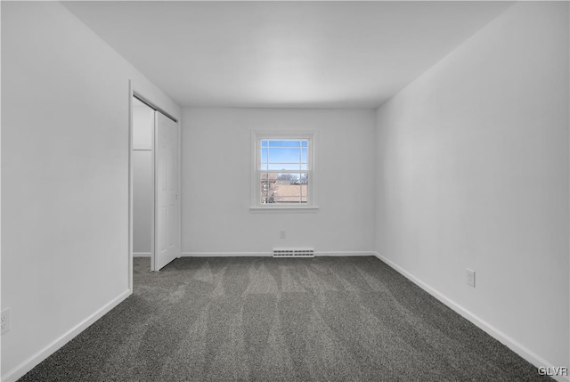 unfurnished bedroom with visible vents, dark carpet, and baseboards