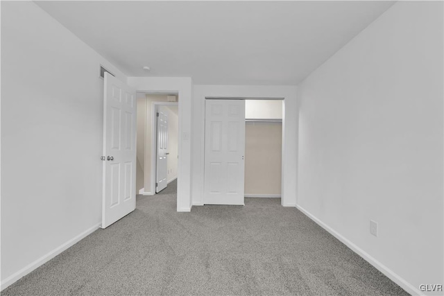 unfurnished bedroom featuring a closet, baseboards, and carpet