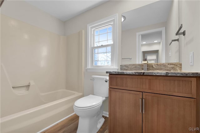 full bathroom with shower / washtub combination, toilet, vanity, and wood finished floors