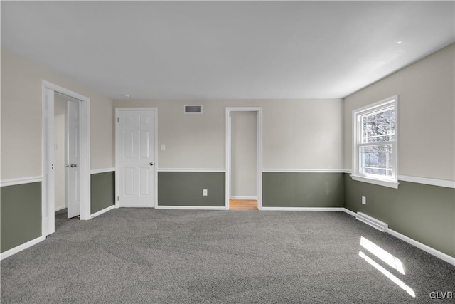 carpeted spare room with visible vents and baseboards