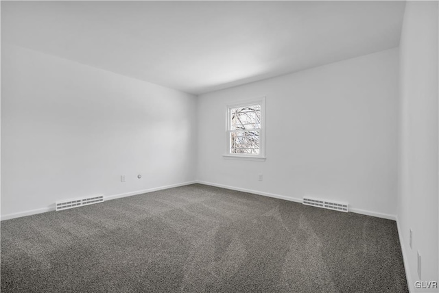 empty room with visible vents, baseboards, and dark colored carpet