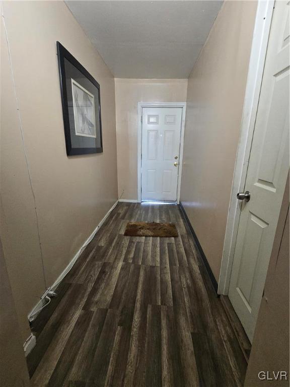 hallway featuring wood finished floors and baseboards