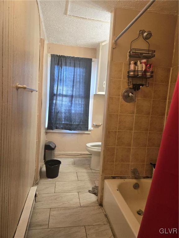 full bath with toilet, a textured ceiling, shower / tub combo, and a baseboard radiator