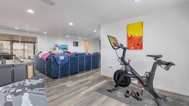 workout room with recessed lighting, baseboards, and wood finished floors