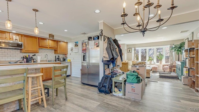 kitchen with light wood-style flooring, tasteful backsplash, open floor plan, crown molding, and light countertops