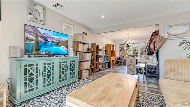 living room with a notable chandelier, visible vents, recessed lighting, and wood finished floors