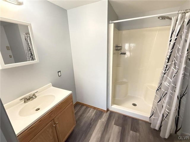 bathroom with a shower with shower curtain, wood finished floors, and vanity