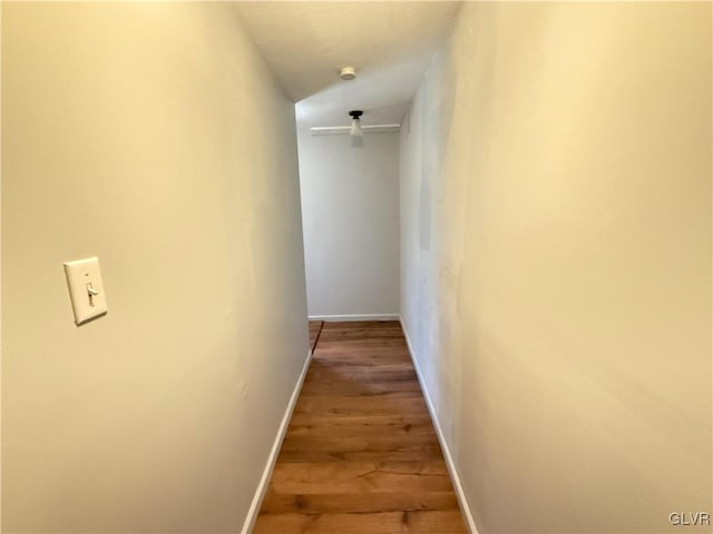 corridor with baseboards and wood finished floors