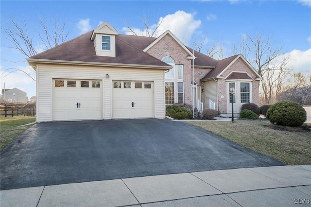 view of front of property with brick siding, a garage, and driveway