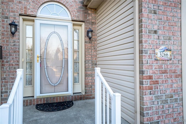 view of exterior entry featuring brick siding