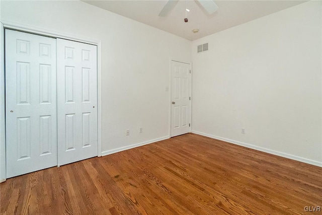 unfurnished bedroom featuring a ceiling fan, wood finished floors, visible vents, and baseboards