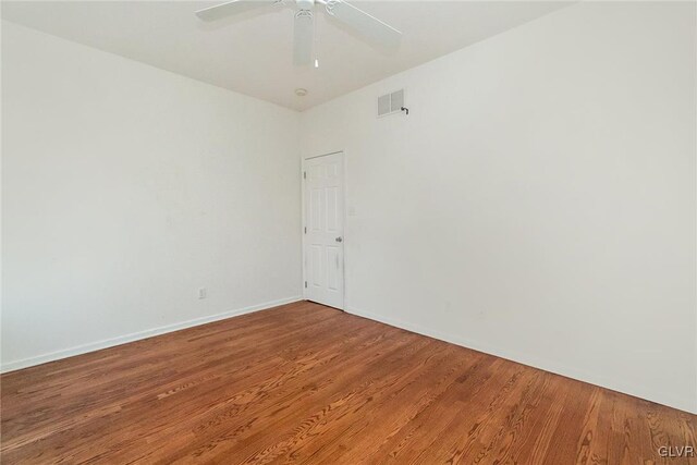 unfurnished room with baseboards, wood finished floors, visible vents, and ceiling fan