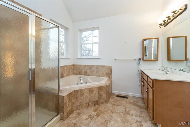 bathroom with visible vents, a garden tub, a stall shower, lofted ceiling, and vanity