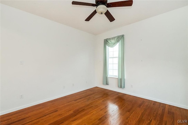 unfurnished room with ceiling fan, baseboards, and wood finished floors