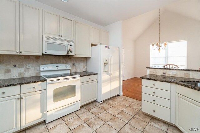 kitchen with white appliances, light tile patterned floors, decorative backsplash, a chandelier, and vaulted ceiling