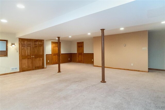 finished below grade area featuring visible vents, wooden walls, carpet floors, recessed lighting, and wainscoting