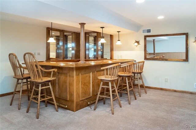 bar with visible vents, carpet flooring, bar area, and baseboards