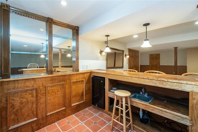 interior space featuring indoor wet bar, decorative light fixtures, recessed lighting, and a sink