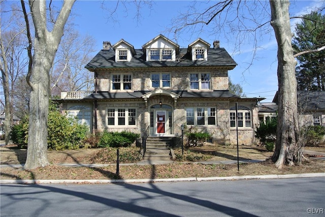 view of front of home featuring stone siding and a chimney