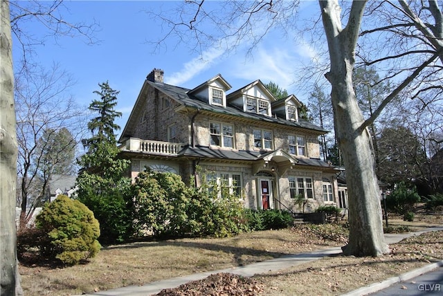 view of front facade featuring stone siding and a chimney