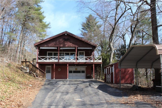 chalet / cabin with a detached carport, driveway, and an attached garage