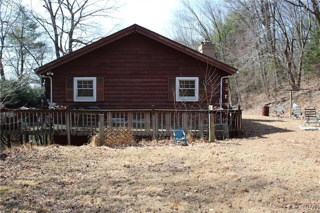 view of side of home featuring a wooden deck and a chimney