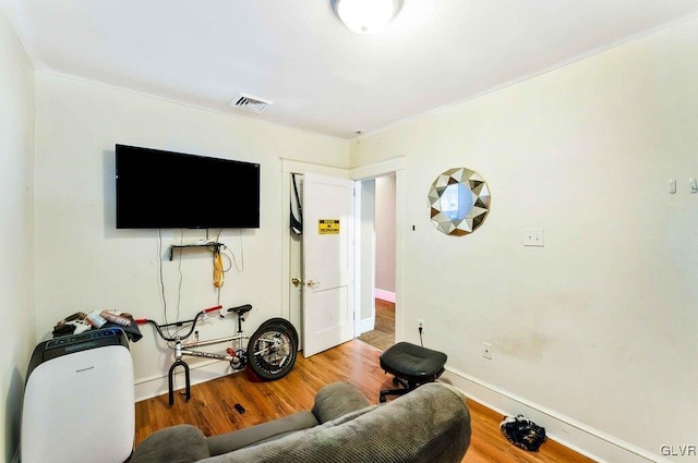 living area featuring visible vents, baseboards, and wood finished floors