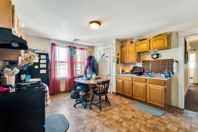 kitchen with brown cabinetry, visible vents, light countertops, and a sink