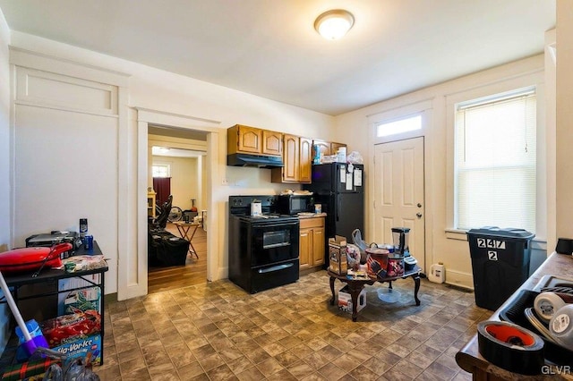 kitchen with black appliances, under cabinet range hood, brown cabinetry, light countertops, and baseboards