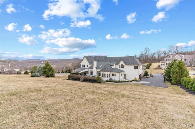 rear view of property with a lawn and a mountain view