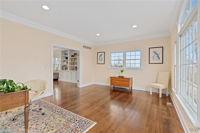 sitting room with visible vents, built in features, dark wood finished floors, crown molding, and baseboards