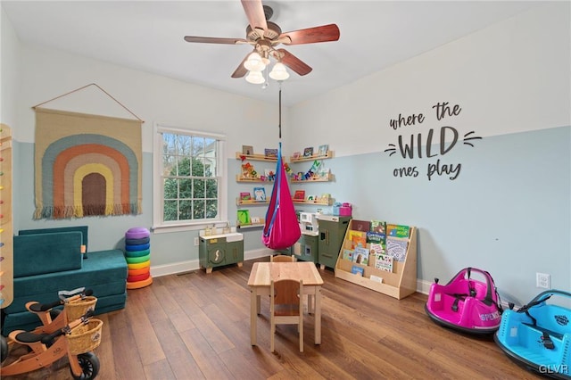 playroom with baseboards, wood finished floors, and a ceiling fan