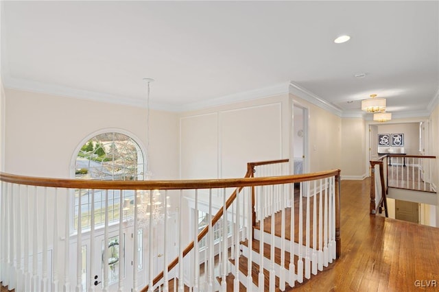 hallway featuring an upstairs landing, an inviting chandelier, crown molding, and hardwood / wood-style flooring