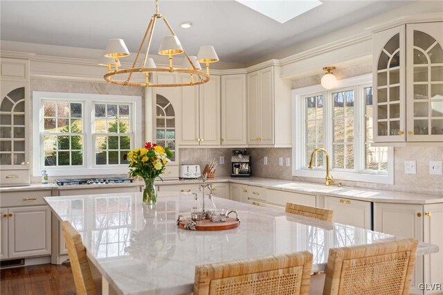 kitchen featuring decorative backsplash, plenty of natural light, a chandelier, and a sink