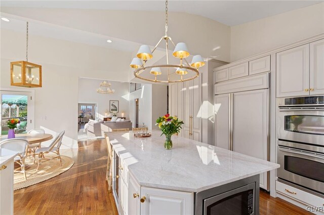 kitchen featuring a notable chandelier, built in appliances, open floor plan, and dark wood-style flooring