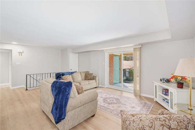 living area with light wood-type flooring and baseboards