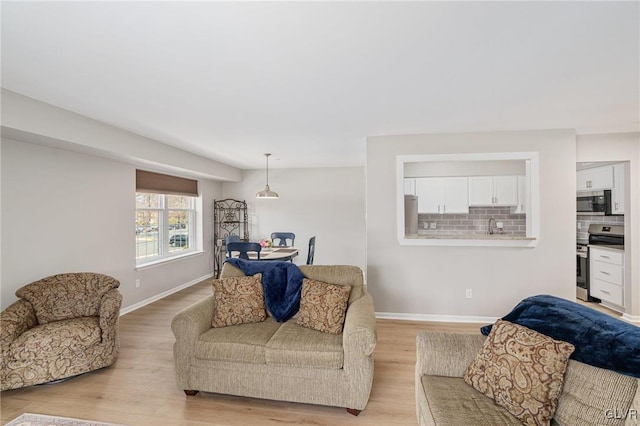 living area with baseboards and light wood-style floors