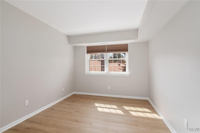 unfurnished room with baseboards and light wood finished floors