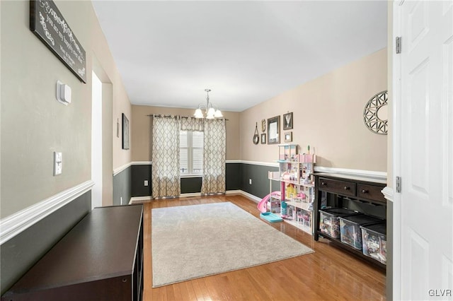 rec room featuring an inviting chandelier and wood finished floors