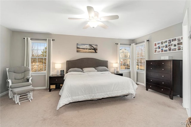 bedroom with light colored carpet, a ceiling fan, and baseboards