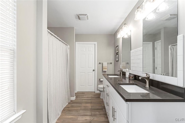 bathroom featuring a sink, visible vents, and wood finished floors