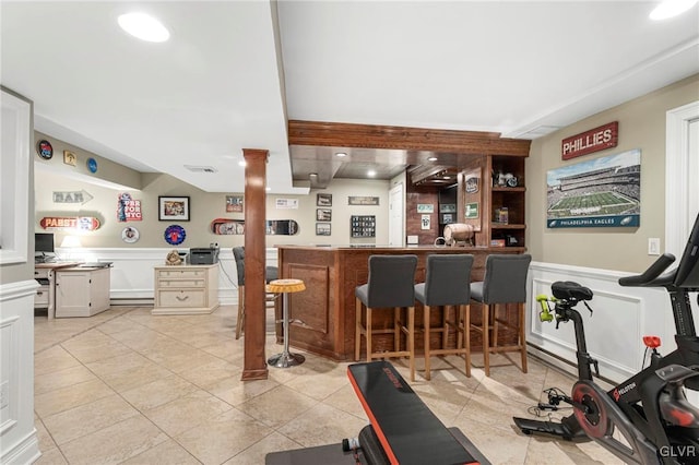 interior space featuring a dry bar, light tile patterned floors, recessed lighting, and wainscoting