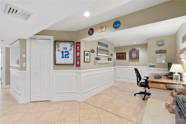 office featuring light tile patterned floors, visible vents, wainscoting, and recessed lighting